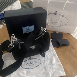 PRADA VÄSKA ÄKTA  - SÄLJER DENNA FÖR 8000kr (snabb affär 7000kr) köptes på prada i Stockholm hösten 2020, påse, dustbag, kvitto & box tillkommer. Den saknar sin AIRPOD POUCH men den går att köpa till i butiken (därav de billiga priset) 