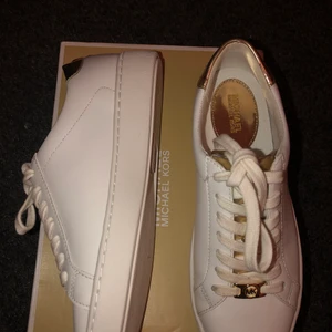 Michael kors  - Säljer mina vita michael kors sneakers med guld detaljer på. Fräscha till en utekväll eller finmiddag. Endast använda 2 gånger men är inprincip nya. Säljer pga för liten storlek. Kan mötas upp alt frakt. Strl 38. Lådan finns kvar och extra beige snöre medföljer