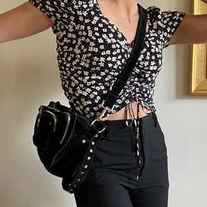 Nunoo väska - Säljer min asfina nunoo väska i mocka. Den har ett stort rymligt fack inuti och även två små fack inuti. Utanpå har den tre fack med dragkedjor. Man kan välja om man vill ha det korta bandet med silvriga metallpluppar på och bara ha väskan hängandes över axeln eller så kan man sätta på det långa bandet på väskan som är justerbart. Det långa bandet går alltså att ta av om man vill (som jag gjort på andra bilden). Köpte väskan för 1199 kr och har använt den ganska mycket men väskan är fortfarande i väldigt bra skick. Köparen står för frakten, jag kan också mötas upp i stockholm💕