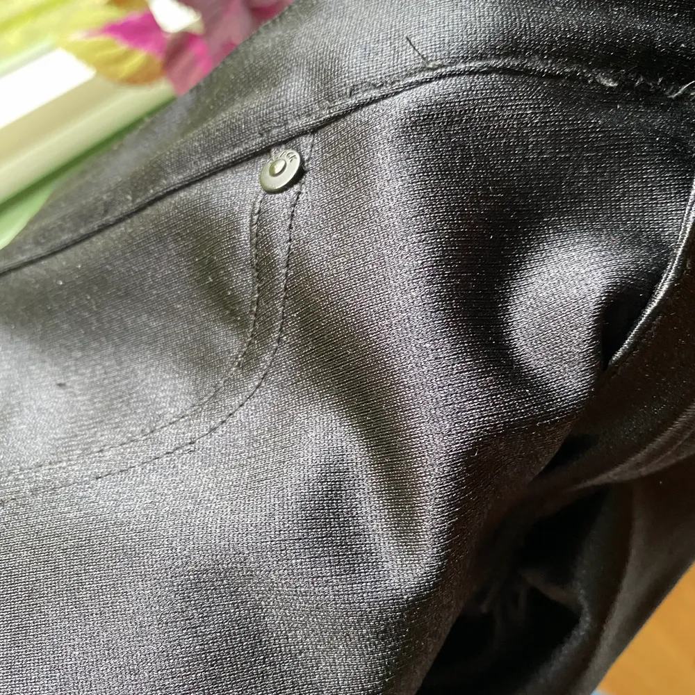 Glansiga svarta byxor från Divided H&M. Ej skinnimmitation utan något glasigt tyg. Väldigt stretchiga över rumpa/lår. . Jeans & Byxor.