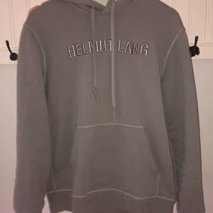 Helmut Lang Hoodie - Grå Helmut Lang hoodie, tröjan är använd men i väldigt bra skick (9/10). Nypris ligger på ca 3000kr. Självklart äkta. Tröjan sitter true to size. Bjuder på frakt.