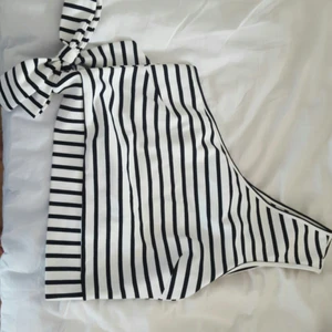 Randig one-shoulder - En croppad randig one-shoulder med en rosett i midjan från nakd. Använd en gång! Köparen står för frakt.