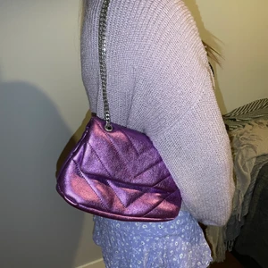 Lila skimrig kedjeväska - Säljer min superfina lila kedjeväska från bershka. Endast använd 1 gång och är i fint skick. Köpte den för cirka 500 kr.