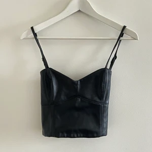 Topp från Zara - Faux leather topp från Zara. Aldrig använd, lapp kvar. Nypris 259kr. Kan mötas upp i Stockholm eller frakta. Tar reda på fraktkostnaden vid behov. Rökfritt hem, allergivänlig Devon rex finns i hemmet. Bud: 120+frakt 