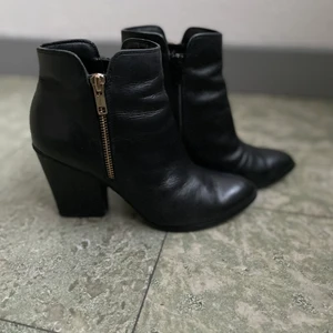 Stövletter Stl 36 - Märke: ellos. Material: läder Stl: 36.                               Detaljer: guld dragkedja (ser silver ut på bilden)      Klacken är bytt till gummiklack som inte låter så mycket när man går. Klacken är något bred vilket gör dom super bekväma att gå i.