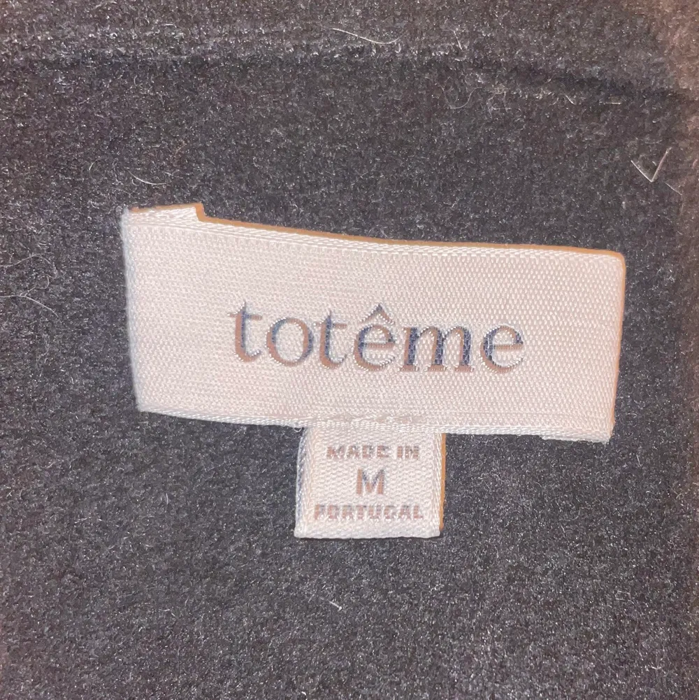 En svart kappa från totême i storlek M med tillhörande skärp. Jättebra skick, orginal pris 5900. Frakt ingår. . Jackor.