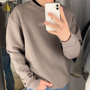 H&M Sweatshirt - Grå sweatshirt med ett litet rosa tryck på bröstet. Perfekt för dig som gillar lite mer oversized. Sälj i nyskick. 