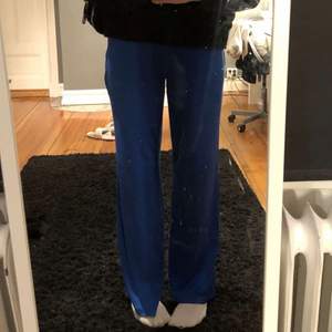 Säljer nu mina blåa byxor! Superfin skrik blå färg!🤩💙 byxorna är i storlek M, perfekt längd på mig som är 166cm!!🌟 Fint skick!!! byxorna är stretchiga och super super sköna! Byxorna är ribbade. Köpt ifrån Gina tricot!!!!