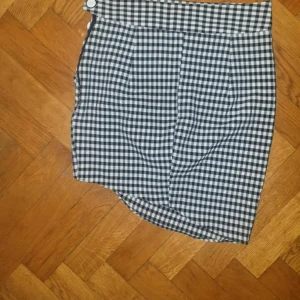 Rutig kjol från Zara storlek 36 - Kjol från Zara storlek 36. Fina detaljer på ena sidan med knappar och plisserad. Aldrig använd