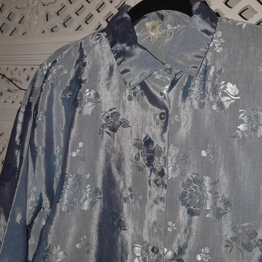 såå fin glansig skjorta i stabilt men silkigt material från 70/80-talet.. utmärkt skick! lite ballongiga ärmar, stabila knappar. fin oversized passform! blommönster. väldigt vacker festblus!!🌻. Skjortor.
