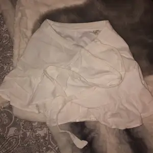 Jättefin och gullig vit volang kjol som man kan knyta i midjan, ifrån Nelly. Använd en gång så väldigt bra skick. Köpt för 399kr, säljer för 110kr+frakt💗💗