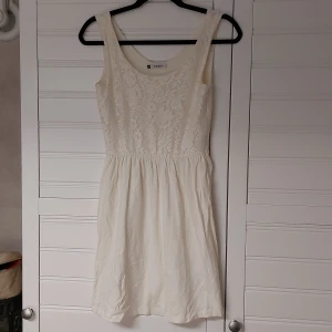 Klänning  - Äggvit klänning med spets upptill, näst intill oavänd 