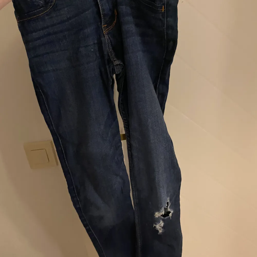 Blåa jeans med slitning på vänstra knät. Från hollister i storlek w25, passar xs.. Jeans & Byxor.