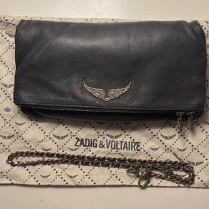 Zadig rock väska  - Säljer min fina zadig väska i modellen ROCK, köpt på zalando för ca 3700. Väskan är använd men i bra skick endast sliten vid ”hörnen”. Det långa bandet saknas tyvärr, den är köpt på zalando så tror jag har ett digitalt kvit