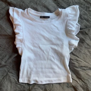 Vit volangtopp zara - En supersöt trendig vit volangtopp från zara strlk S men sitter som en xs💓 om man vill ha spårbar frakt så kostar det 66kr annars kostar det 24kr💓💓 !Första bilden är lånad!