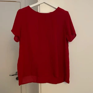 Röd blus med spets i ryggen - En välanvänd, fin blus i röd färg med ett V i ryggen av spets. Är av märket Jacqueline de Yong och är i storlek 40. 
