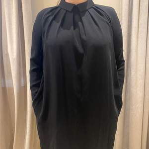 En svart klänning med fin krage i stolek 40. 
