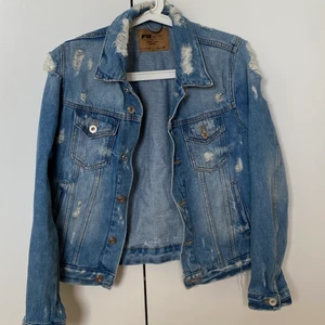 Jeansjacka  - Jeansjacka med mycket slitningar, har inte blivat använd på flera år. Snygg att styla jeans på jeans😍 storleken är M och jag är själv en M/S men tycker att den är mindre än en M. Är man intresserad skulle jag säga att den är mer som en S.