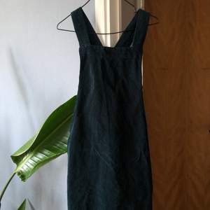 En mörkgrön hängselklänning från Urban Outfitters. Säljer pga inte min storlek. Det är manchestertyg så den är ribbad.