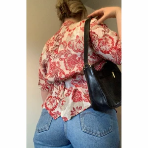 Rödblommig blus - Snygg och funky skjortig blus med det klassiska röda hibiskusmönstret! 💋 😳 Finns knytsnören i ryggen så man kan bestämma hur tajt den ska sitta. På mig är det lite liten, så den passar den som är lite nättare än mig. Någon som har storlek 36-38 kanske. ❤️😆👌🏼