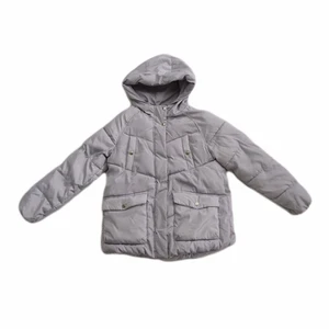 En jacka  - En grå/blå puffjacka. Två fickor på bröstet och två fickor nere på jackan. Använd få gånger så den är som ny.