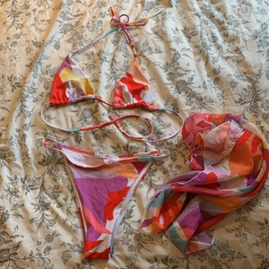 Färgglad bikini - Superfin bikini som jag beställt i storlek M men den var för liten på mig. Har endast testat med trosor under, trosskyddet sitter kvar på underdelen. Också en strandkjol som man knyter själv efter sina mått. 70 kr + (66 kr frakt, spårbart).