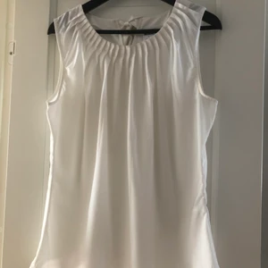 Vit blus - Vit blus i storlek L från Vero Moda. Den passar dock även M. Rynkad upptill och har en rosett på ryggen. Knappt använd 