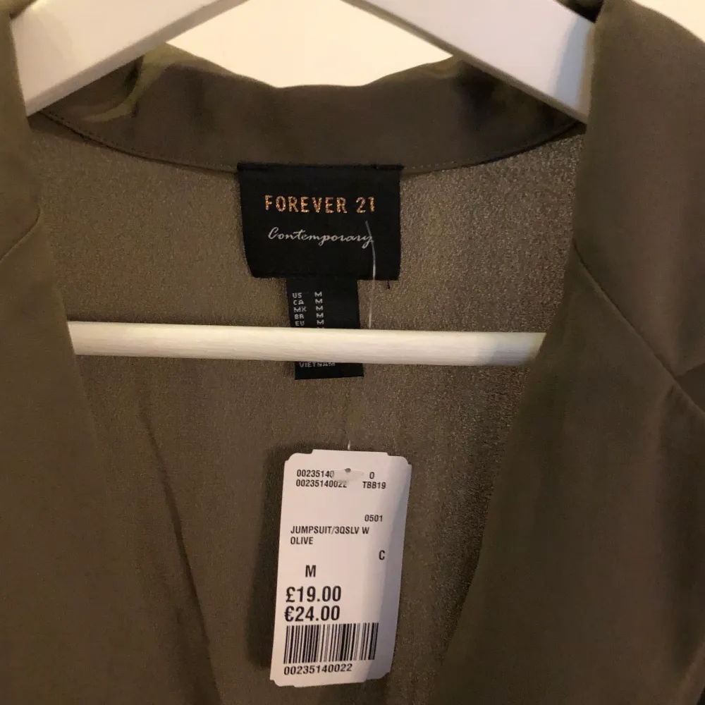 En militär grön klänning ifrån forever 21 i stl m den är aldrig andvänd och lappen sitter fortfarande kvar den har ett skärp i midjan som man kan spänna åt.. Klänningar.