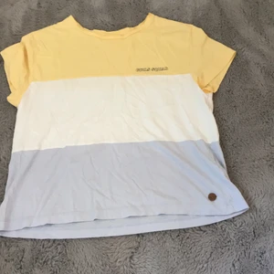 Gul, vit och blå T-shirt  - Säljer denna vita, gula och blåa T-shirten från Kappahl. Jag har använt den ganska mycket men det finns inga synliga tecken på användning. Jag köpte den för 250 och säljer den nu för 100kr