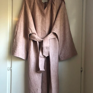 Carin Wester linnekappa - Jättefin kappa från Carin Wester, i ljungrosa 100% linne med innertyg. Med sidorutor, slag och något hög krage. Dolda knappar. Jättehärlig vårjacka, sval och skön!  Modellen är oversize och något klockformad. Storlek 38, men väldigt stor i storleken (jag har vanligtvis 42).  Finns för upphämtning i Sköndal/Sthlm eller postas mot betalning. 