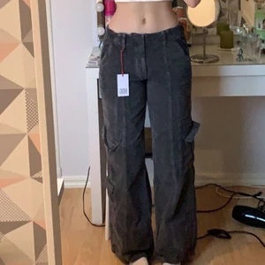 Y2K cargo, Urban Outfitters, S - Snygga grå Y2K cargo byxor från Urban Outfitters i storlek S. (Den sista bilden är samma plagg, från deras hemsida i en annan färg). Jag är 171cm och dem lär passa ifall man är kortare också. Köpte dem för några månader sedan för €69.00(739kr) men dem har inte blivit använda alls. Skriv för fler bilder vid intresse. Säljs för 350 plus frakt 