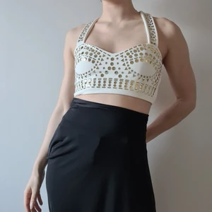 Vit bralette med guldiga nitar - Vit topp med guldiga nitar, både fram och bak, breda axelband. Bekväm och sitter smickrande. Dragkedja på ena sidan (den går att öppna helt, men är lite trög precis i slutet).