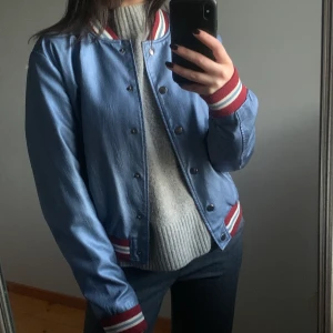 Jacka  - Blå collage jacka med vinröda detaljer strl M men relativt liten i storleken