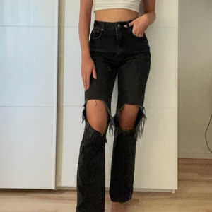 Raka svarta jeans med hål från Nakd - Säljer ett par  svarta raka jeans med stora hål vid knäna. Fin passform då dom är tajtare vid höfterna och mer luftigare vid benen. På mig som är 173 är dem en aning korta. Jeansen är köpta för 499 kr på Nakd men jag säljer för 150 kr, köparen står för frakten!🖤🖤 