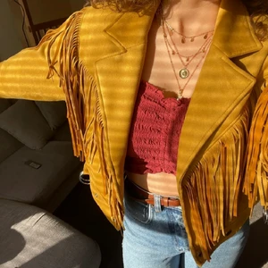 Gul fransjacka i mockaimitation - (Bilderna är tagna av den förra säljaren)                               Säljer den här otroliga fransjackan i mockaimitation! Jag köpte den här på Plick, och den är i väldigt bra kvalité. Den är köpt i Frankrike för ganska länge sedan. Jag älskar den så mycket, men jag använder den tyvärr inte så ofta som jag önskat.