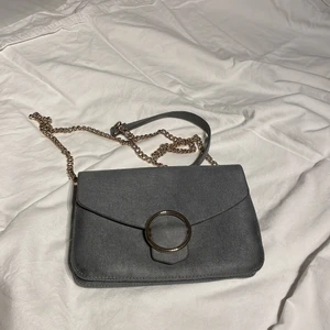 axelväska från h&m - grå med guldiga detaljer, aldrig använd, banden går att stoppa in för annan look, nyskick🖤🖤