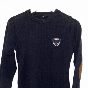 Ribbstickad tröja - Säljer fin ribstickad tröja. Den är marinblå och i skönt stretchigt material med brun mockaimitation vid armbågarna. Fungerar bra i stallet och privat. Köpt på hööks. Storlek XS med är i töjbart material💖 kan leverera eller mötas upp, köparen står för frakt.