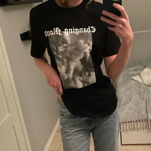 Svart tröja med tryck - En svar tröja från Nelly med ett tryck på. Den är i nyskick. T-shirten är i storlek S men passar flera storlekar.