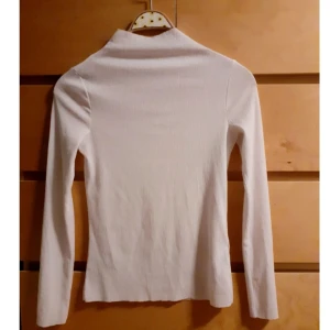 Långarmad vit turtleneck  - En vit turtleneck från HM. Tyget är tunt och lätt genomskinligt och har små små sträck i sig vilket ger en cool kontrast när man matchar olika outfits (om mönstret inte syns är det bara att hojta till så kan jag skicka bilder). Kragen är lite längre och avkuttad. Själva tyget är även något strävare, men inget man tänker på. Tröjan är i  bra skick och storlek 38