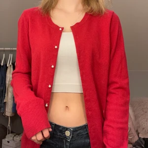 Röd stickad kofta med pärlor - Röd stickad kofta med krampar i form av pärlor, passar storlek x-small till medium ⭐️ köpare står för frakt, spårbar eller inte. Pris kan diskuteras.