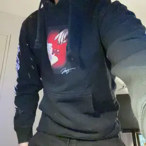 Svart Hoodie mdd tryck på magen och högra armen. 