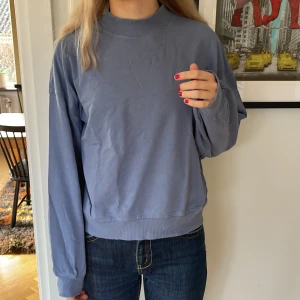 Collegetröja från weekday  - Weekdaytröja i blått med högre krage 