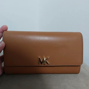 Äkta MK väska  - Gör mig av med min väskkollektion! Helt oanvänd, plasten kvar på. Kvitto finns. OBS! Redan skamligt låga priser, svarar inte på prutande. Bästa vore om vi möts upp. Finns i Sthlm City. Annars betalar mottagaren frakten. Mvh Laura 