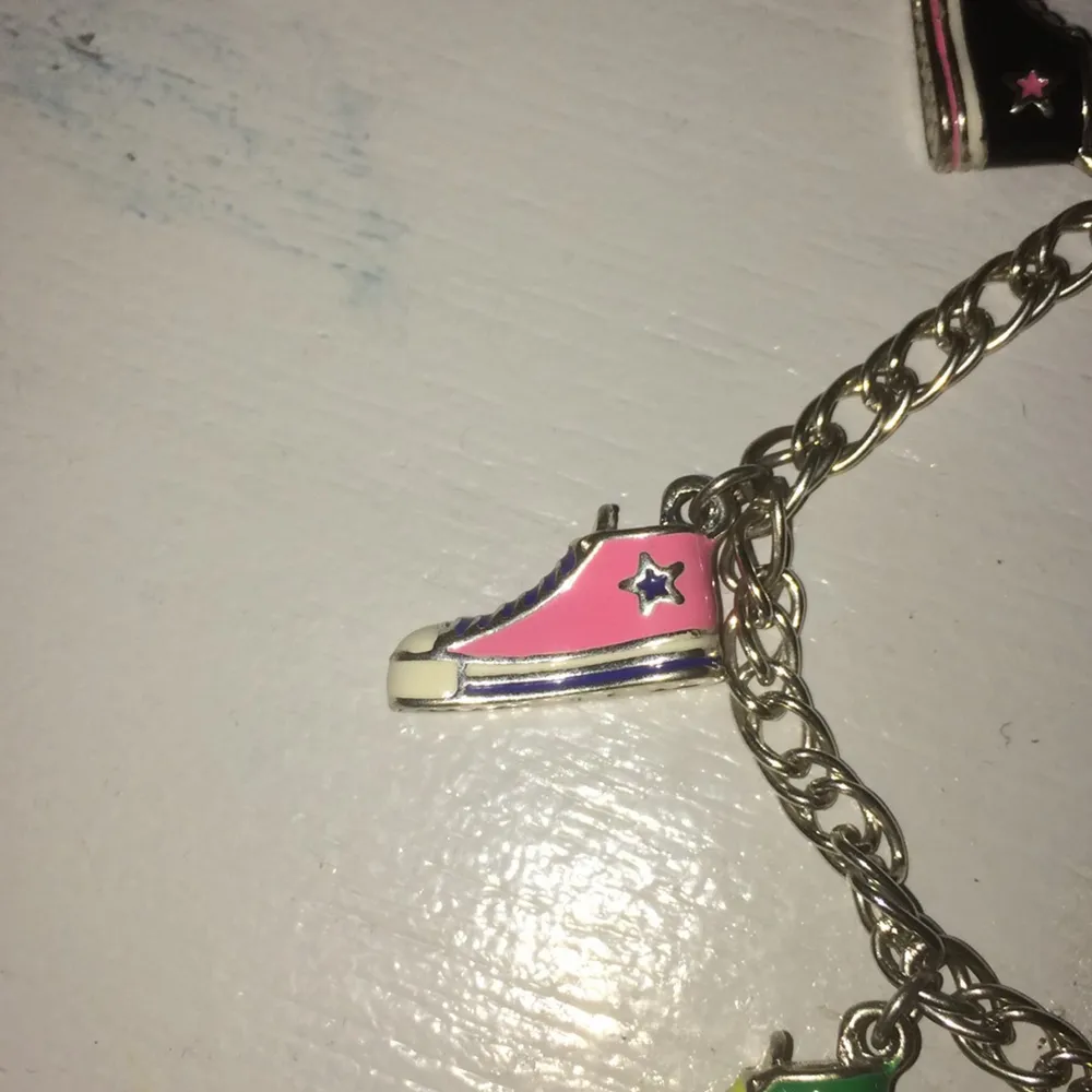 Armband med Converse skor. Nypris 80kr mitt pris 10kr. Kedja på 20cm. 5st skor på armbandet. Silvrigt. Säljs pga ej använt. Inget slitage.           Köpare står för frakt. Accessoarer.