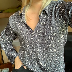 Mönstrad blus från bikbok - Söt blus från bikbok i storlek XS, passar även S. Färgen är mörkgrå med ljusa leopardfläckar. Nästan lite som satin i materialet fast mjukare.