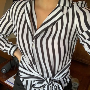 Blus från nakd i stl 34 - Säljer denna fina blusen med skjort-krage från na-kd i storlek 34. Har långa band vid midjan som man kan knyta hur man vill. Aldrig använd