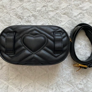 Midjeväska  - Matt, svart midjeväska med guld detaljer. Helt ny! Aldrig använd. Har en innerficka utan dragkedja. 