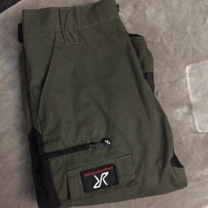 Revolution race fritidsbyxor - Militärgröna/svarta fritidsbyxor från RVRC i storlek 36, går att spänna vid foten