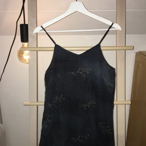 Superfin svart längre klänning - Lång klänning i svart med vita och gula/guldiga blomdetaljer. Snygg neckline och i väldigt bra skick. Fler bilder finns vid intresse.✨✨