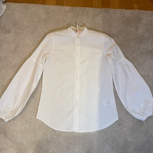 Vit Ralph lauren blus/skjorta - Superfin Vit Ralph lauren blus/skjorta med fina ärmdetaljer i strl XS som även passar en liten/normal S. Inköpt i Usa på Ralph lauren store.
